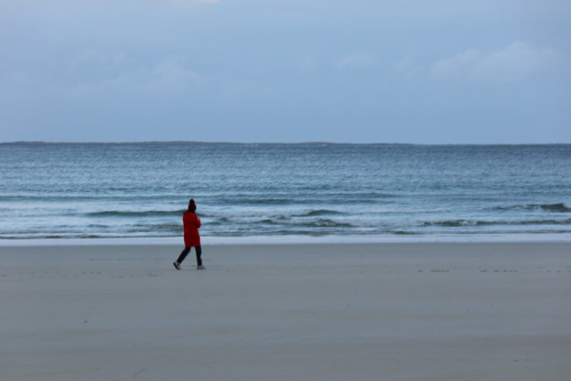 Einsame Spaziergängerin am Strand von Portnoo, Donegal