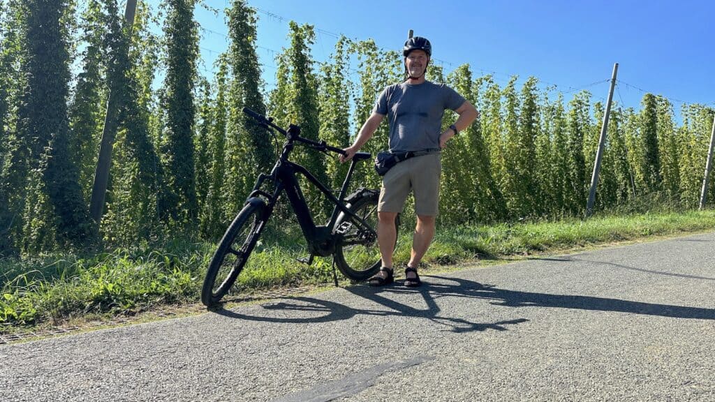 Hubert Mayer vom Travellerblog.eu mit Fahrrad bei den Hopfenwochen vor den Hopfenfeldern im Nürnberger Land