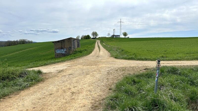 Hier geht es nach links. Wer genau hinsieht, sieht auch den Pfeil auf dem Schild am Pfosten