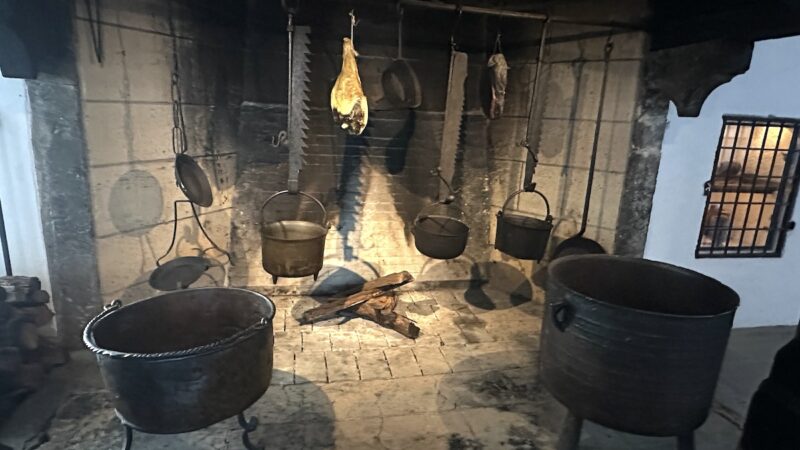 Feuerstelle mit Töpfen an den Ketten mit Zacken aufgehängt